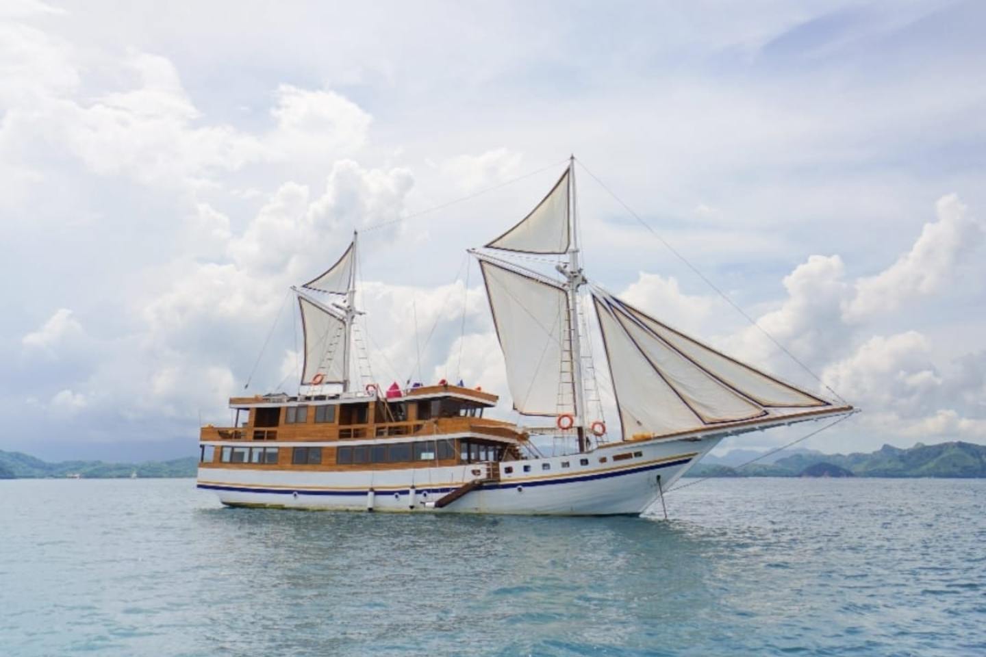 kapal phinisi berlayar di perairan labuan bajo saat sailing trip